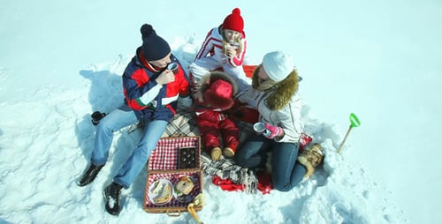 Family Picnic in the Snow on Sunny Day