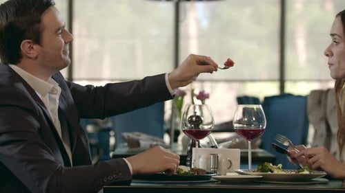 Man feeds Woman food at Restaurant during Lunch