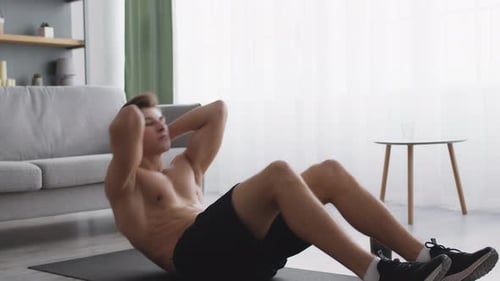 Muscular Man Doing Sit-Ups at Home