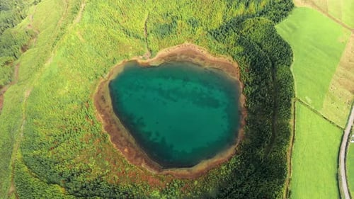 Drone Footage Over the Greenish Lake in Crater Surrounded with Vibrant Landscape