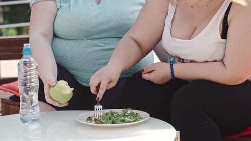 Women Eating Salad and Apple Outside