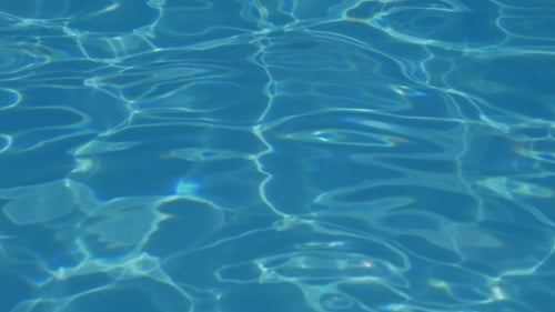 Wellenwasser im Schwimmbad mit Sonnenreflexion