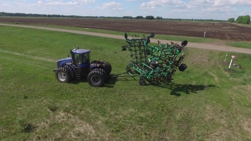 Tractor with Planter Sows Black Boundless Field