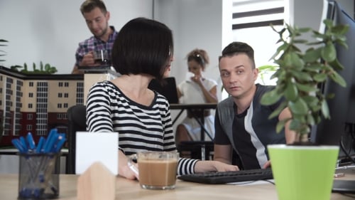 Coworkers Collaborating on a Computer in a Modern Office
