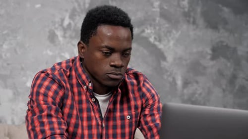 Happy Man Smiles at Laptop Screen