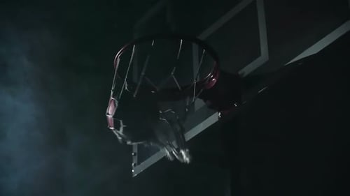 Basketball Falls Through Net in Dramatic Lighting