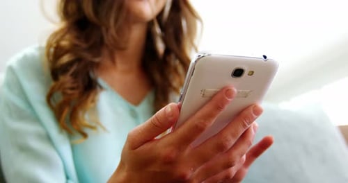 Woman Using Smartphone in Bright Indoor Setting