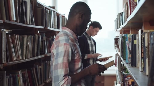 Male Students Looking for Books in Library