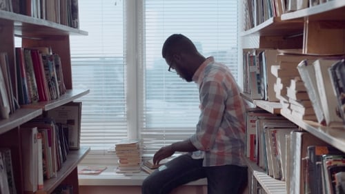 Young Adult Reads Books in a Library
