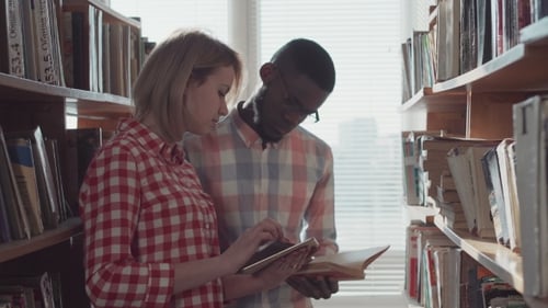 Students Reading Together in Library Stacks