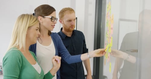 Team Brainstorming Ideas with Sticky Notes in Office