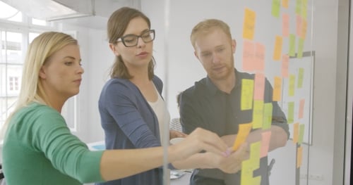 Team Brainstorming Ideas with Sticky Notes in Office