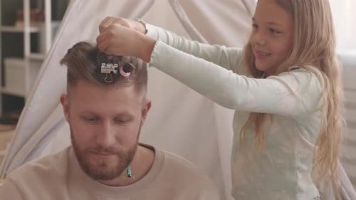 Child Plays Hairdresser with Smiling Bearded Adult