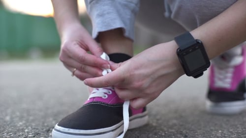Adult Ties Sneakers and Touches Smart Watch