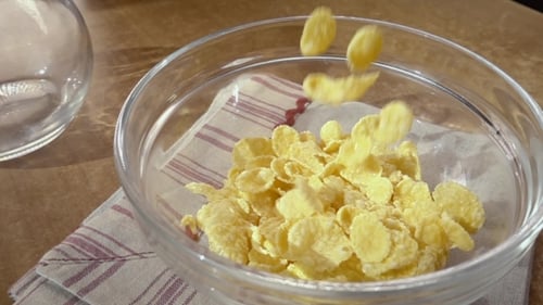 Pouring Corn Flakes Into a Glass Bowl
