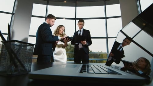 Junges Geschäftsteam beobachtet gemeinsam die Daten auf dem Tablet, diskutiert, lächelt