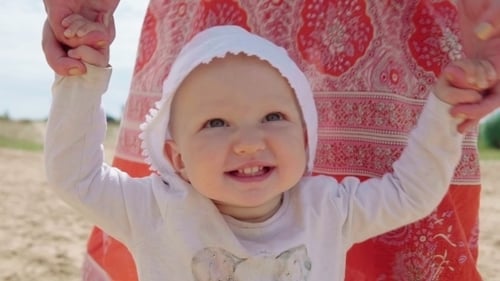 Happy Baby Learns to Walk with Help of a Mother