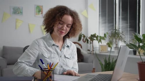 Woman on Video Call Taking Notes Indoors