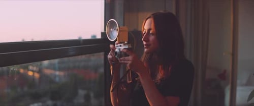 Woman photographer taking a picture from the balcony close up