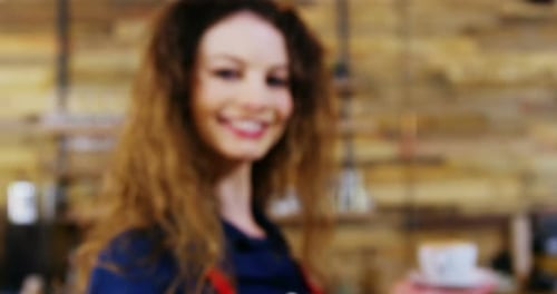 Smiling Woman Holds Cappuccino in Cafe