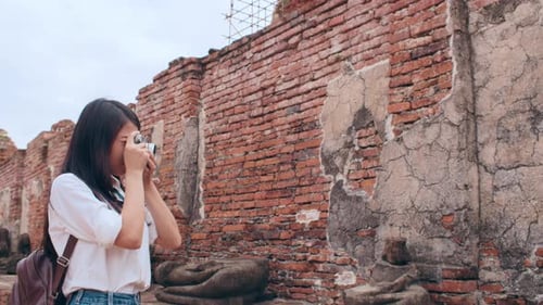 Asian woman using camera for take a picture while spending holiday trip at Ayutthaya,