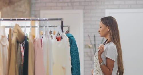 Mulher feliz experimentando roupas em uma loja de shopping
