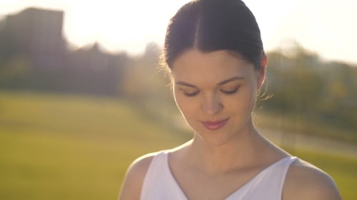 Pregnant Woman Holding Her Abdomen in a Grassy Field