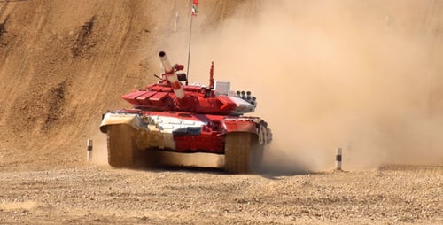 Red and White Tank Racing Down a Sand Hill