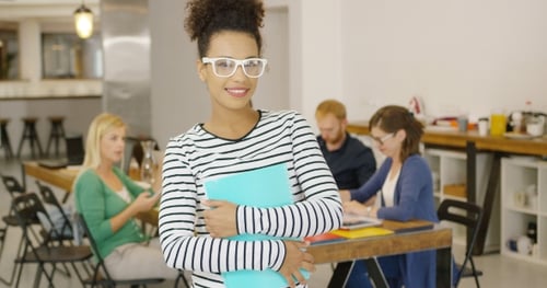 Confident Young Woman with Folders in Modern Office