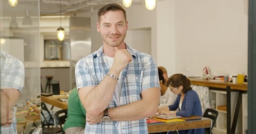 Confident Man Gives Thumbs Up in Modern Workplace