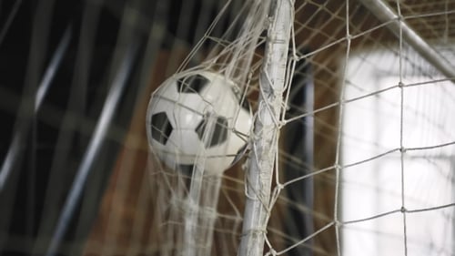 Tres tiros de balón de fútbol en la red de portería