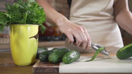 Chef Peels Cucumbers Fof Making Vegetable Salad with Fresh Greens, Vegetarian Dishes, Cooking Food