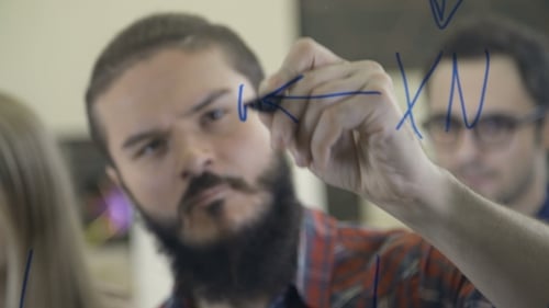 L'équipe créative réfléchit et écrit sur du verre