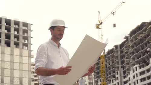 Architect or Engineer Working in Hard Hat Browsing Building Project of Construction Site with