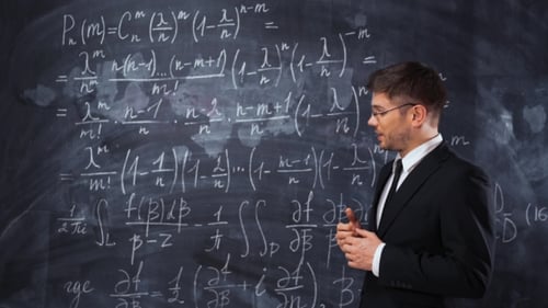 Man Explaining Math Equations on a Blackboard