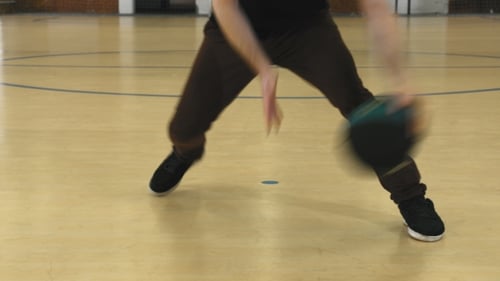Jeune homme pratiquant au dribble de basket-ball