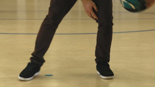 Jeune homme pratiquant au dribble de basket-ball