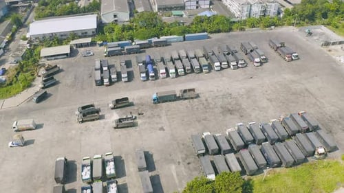 Aerial top view of truck cars parking stock lot row in industry factory, dealer inventory import