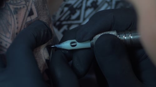 Tattoo Artist Demonstrates the Process of Making Getting Tattoo with Paint. Sterile Gloves. Master