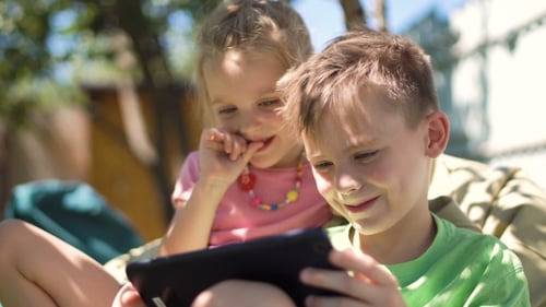 Children Enjoying Tablet in Backyard
