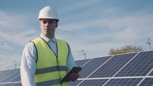 Technician Walks Beside Array of Solar Panels