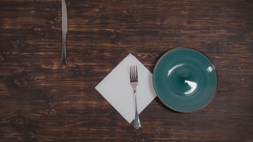 A Green Plate Moves on the Table with Cutlery