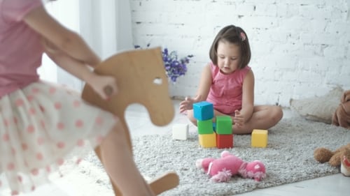 Two Little Girls Playing with Toys at Home