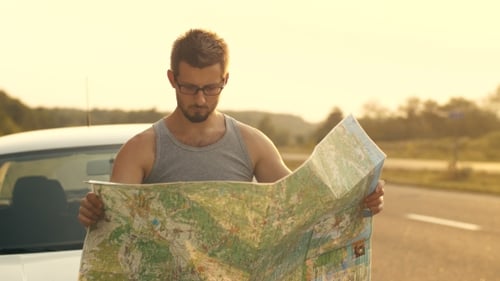 Man Reading Map on the Car's Hood