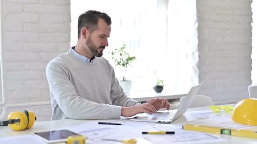 Serious Young Architect Standing Up Going Away at Work