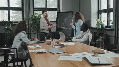 Team Discussing Charts in a Workplace Meeting