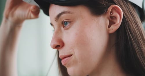 Close up of young woman from the side putting on vr goggles