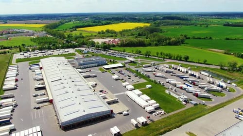 Aerial top down view of the big logistics park with warehouses, loading hub and a lot of semi trucks