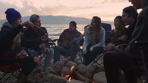 Friends Gather Around Campfire on Beach at Sunset