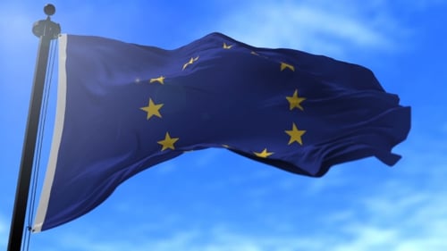 Waving European Union Flag on Pole Against Blue Sky
